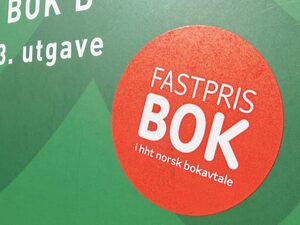 Grønn bok med rødt klistremerke om 