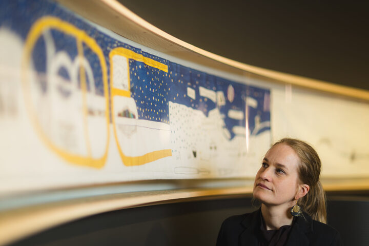 Ingeborg Høvik foran en kopi av Britta Marakatt-Labbas Historjá (originalen er på utlån). – Broderiet viser en sirkulær forståelse av tid og historie, der ånder, guder, gudinner og forfedre er med i nåtiden, sier hun.