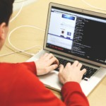 En mann koder eller programmerer på en datamaskin