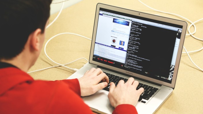 En mann koder eller programmerer på en datamaskin