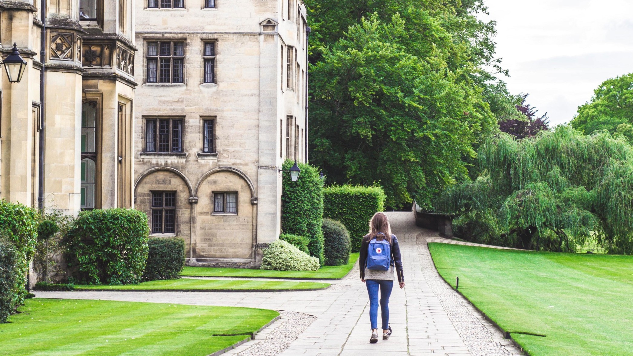 En enslig student utenfor King's College, University of Cambridge, Cambridge, Storbritannia