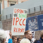 Demonstrant holder plakat med teksten "Lytt til forskningen IPCC rapport"