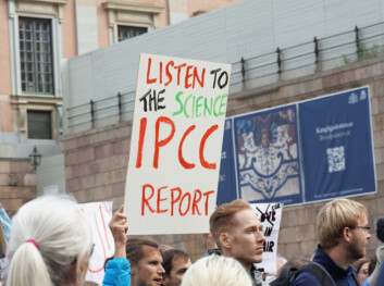 Demonstrant holder plakat med teksten "Lytt til forskningen IPCC rapport"